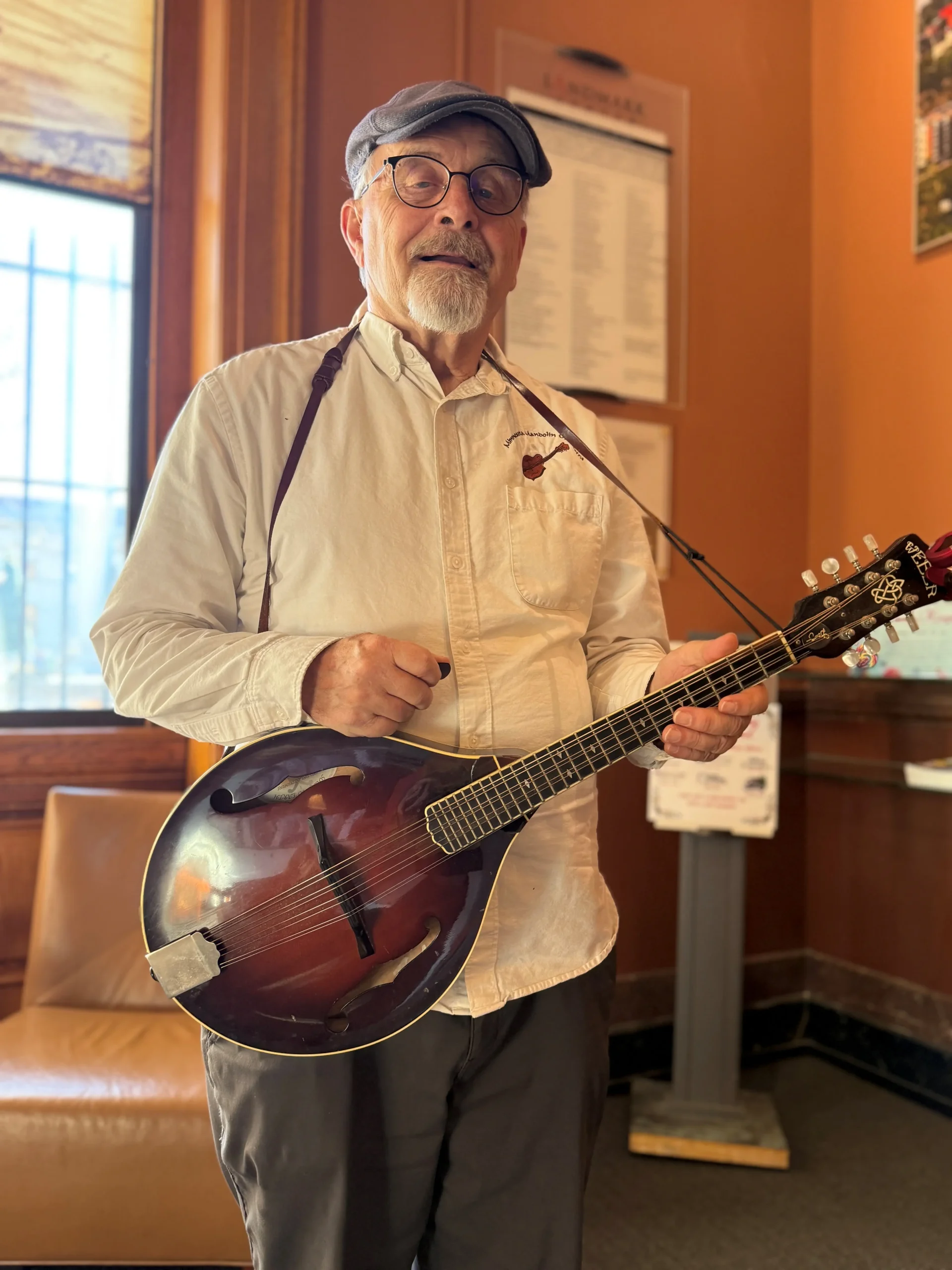 Man poses with a mandola at the Landmark Center